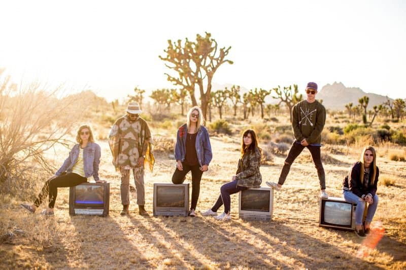 foto de banda tomada en un desierto con televisores crt