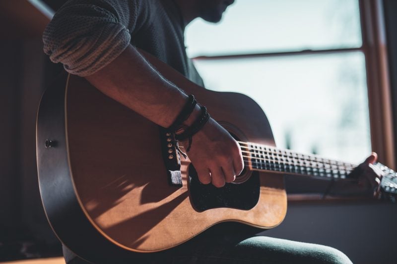 person playing acoustic guitar